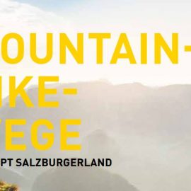 Gelber Text MOUNTAIN-BIKE-WEGE über einer nebligen Berglandschaft bei Sonnenaufgang; kleinerer Text darunter: KONZEPT SALZBURGERLAND.