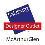 Logo mit Salzburg Designer Outlet in blauen und roten Blöcken über McArthurGlen, das Wirtschaftskooperationen zeigt.